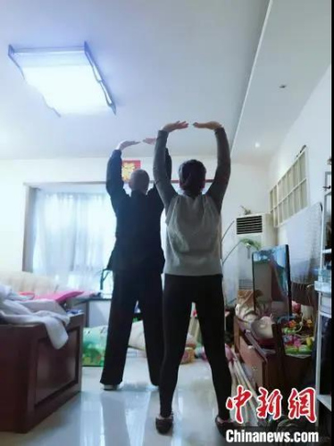 馬丁教妻子練習(xí)八段錦。