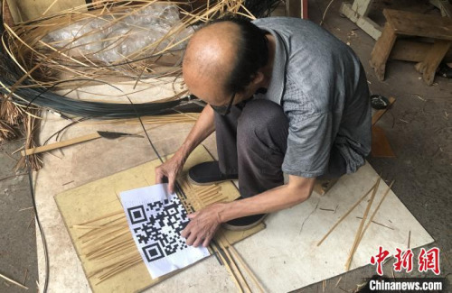 謝世仰將竹篾有序地擺在地上，對照著打印出來的二維碼開始編織?！∨砝蚍?攝