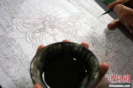 圖為唐卡繪畫班學員按《造像度量經(jīng)》繪制唐卡。　江飛波 攝