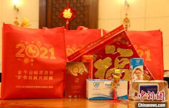 中國駐菲使館此次發(fā)放的“春節(jié)包”，有口罩、面罩、消毒濕紙巾等防疫物資，還有精心制作的春聯(lián)、“?！弊?、牛年生肖飾物和慰問卡，滿載著祖(籍)國政府對海外同胞的關心和惦念?！≈袊v菲律賓使館供圖 攝