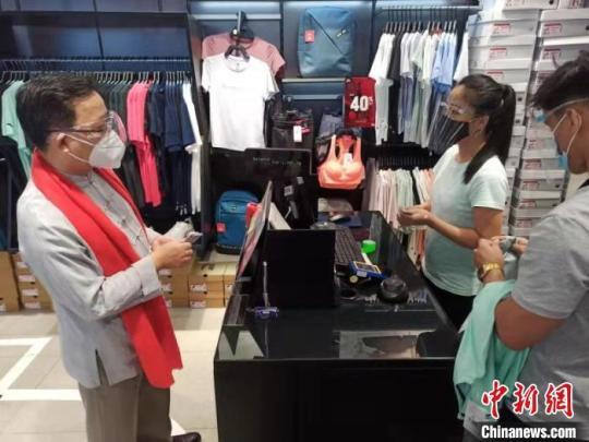 黃溪連大使當(dāng)場(chǎng)購買商品，支持中菲商業(yè)發(fā)展。中國駐菲律賓使館供圖