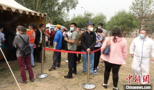 在現(xiàn)場排隊(duì)等候接種疫苗的人們?！』蕰员?攝