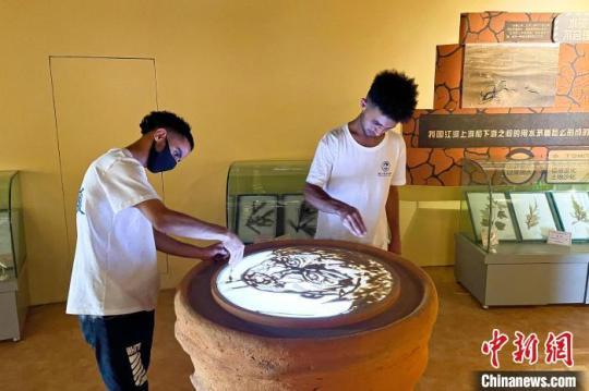 留學(xué)生在中國(guó)防沙治沙展覽館體驗(yàn)沙畫(huà)。　李佩珊 攝
