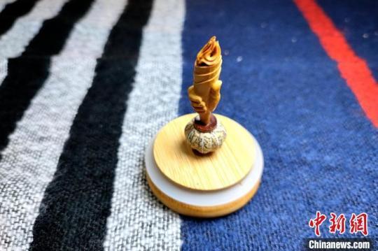 圖為黃樹立創(chuàng)作的核雕“火炬”?！∶疯O瀧 攝
