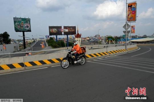 當?shù)貢r間4月16日，柬埔寨金邊，一名食品配送員在空蕩蕩的馬路上行駛。柬埔寨政府14日晚宣布，首都金邊和干拉省大金歐市從4月15日零時起“封城”14天，直至4月28日。除“重要服務”領域，任何人不得隨意外出。