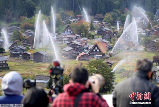 資料圖：位于日本岐阜縣白川村的白川鄉(xiāng)合掌造村落舉行放水演習，引來眾多游客圍觀。