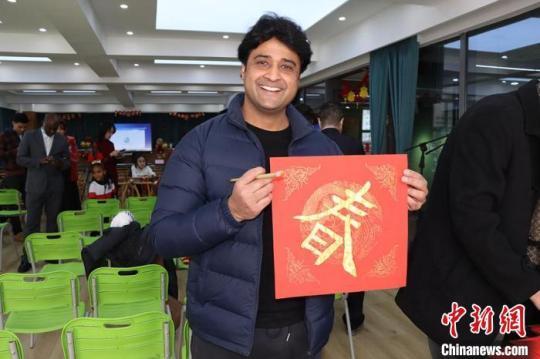 圖為留學(xué)生展示自己寫的“春”字，感受中國年文化。　西北師范大學(xué)國際文化交流學(xué)院供圖