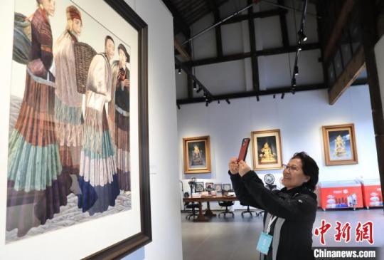 一位海外華媒代表在一家博物館拍攝展出的蜀繡作品。　王磊 攝