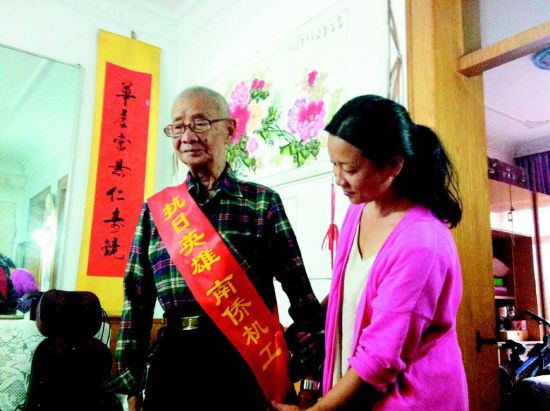 中國僑網(wǎng)女兒蘇小紅為老人整理綬帶。(《太原晚報》/裴怡 攝)