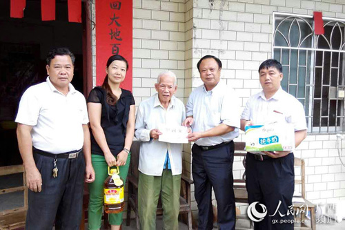 中國(guó)僑網(wǎng)玉林市、容縣僑聯(lián)的領(lǐng)導(dǎo)干部與韋德榮老人(中)在一起。
