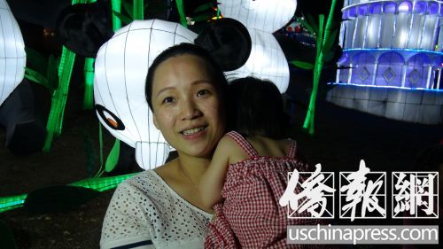 蔣女士抱著女兒在洛縣博覽會觀賞中秋花燈。(美國《僑報》/高睿