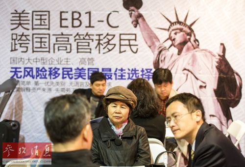 一家公司工作人員在北京春季房展會(huì)向參觀者介紹海外投資移民情況。(參考消息)