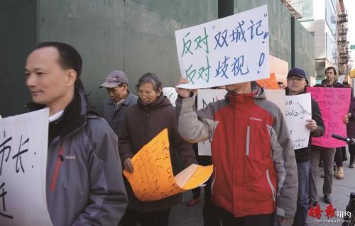 參與示威民眾高舉中文抗議標語。(美國《僑報》/陳辰