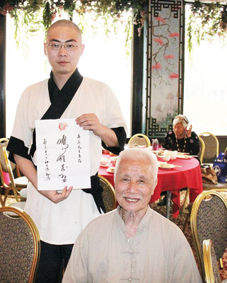 書畫家江天源為吳蔚(左)題寫「鵬程萬里」表示祝賀。