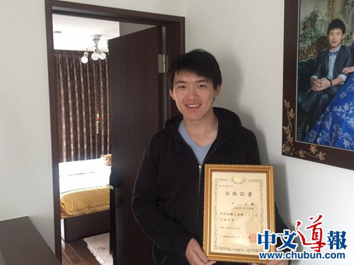 何彥徵手捧司法考試合格證書(日本《中文導(dǎo)報(bào)》)