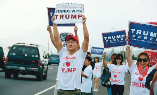 華裔特朗普助選團的成員在路邊高舉標語支持特朗普。(美國《僑報》/資料圖)
