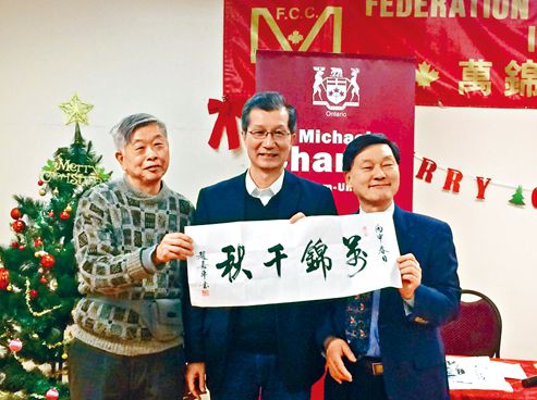 中國(guó)僑網(wǎng)萬(wàn)錦加華聯(lián)會(huì)主席吳建忠醫(yī)生(右)和該中心長(zhǎng)者代表向陳國(guó)治(中)贈(zèng)送書(shū)法作品。(加拿大《星島日?qǐng)?bào)》)