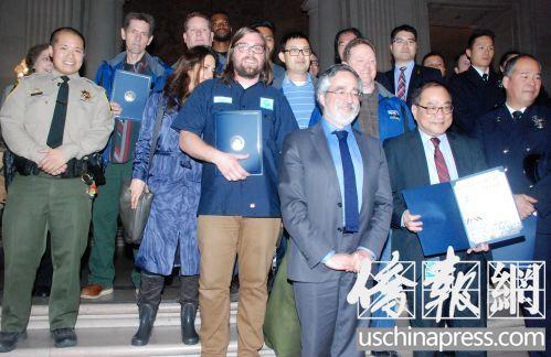 中國(guó)僑網(wǎng)市議員佩斯金和受表彰的救火英雄合影。(美國(guó)《僑報(bào)》/吳卓明 攝)