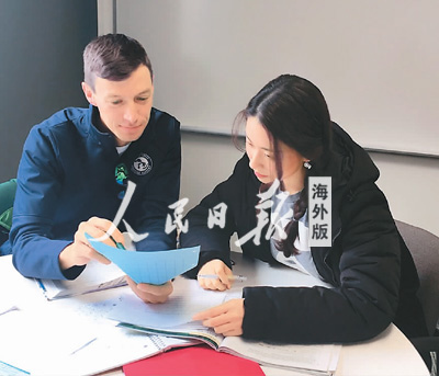 中國僑網(wǎng)賀楚萌(右)和外國同學(xué)在討論如何修改論文