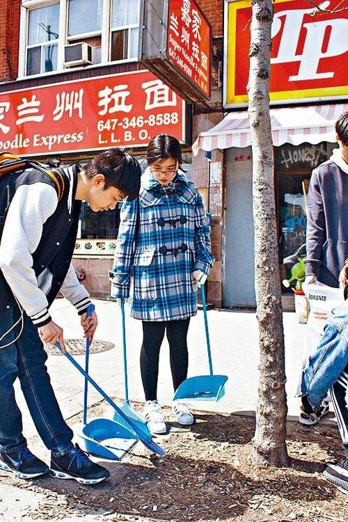 中國僑網(wǎng)義工們打掃街道。(加拿大《星島日報(bào)》)