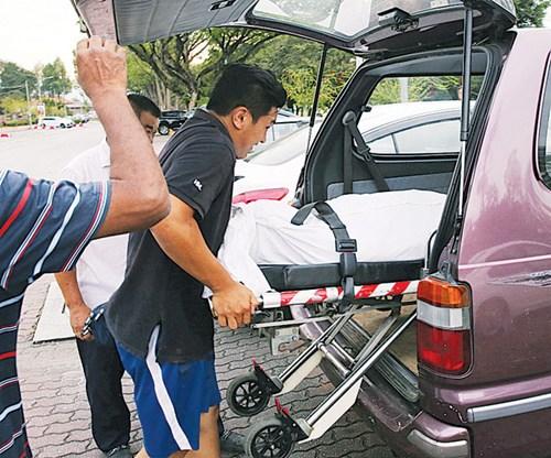 中國(guó)僑網(wǎng)死者的遺體被抬上車(chē)準(zhǔn)備送往醫(yī)院太平間。(馬來(lái)西亞《光華日?qǐng)?bào)》)