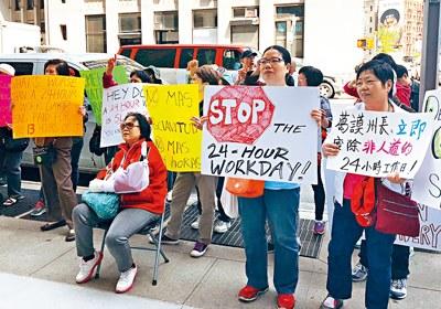 中國(guó)僑網(wǎng)手持“停止24小時(shí)工作日”標(biāo)語(yǔ)華人護(hù)理工。(美國(guó)《星島日?qǐng)?bào)》圖片)