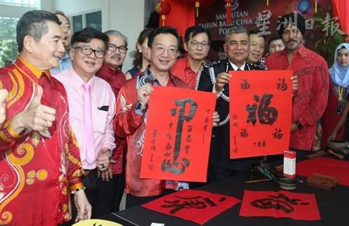 中國僑網(wǎng)卡立和黃惠康在吉隆坡警察總部展示黃惠康的揮毫作品。(馬來西亞《星洲日報》)