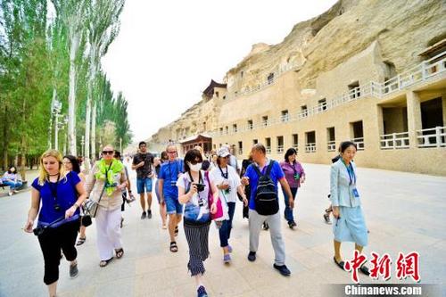 中國僑網(wǎng)圖為6月24日,國內(nèi)外旅行商考察團在敦煌莫高窟參觀考察。 王斌銀 攝