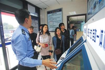 中國僑網(wǎng)通州公安分局出入境自助服務廳,民警介紹自助簽注機的功能和使用方法。