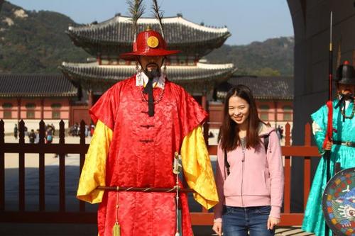 中國(guó)僑網(wǎng)資料圖片:在韓國(guó)首爾景福宮外,中國(guó)游客與韓國(guó)守城門(mén)將合影。(新華社/姚琪琳 攝)
