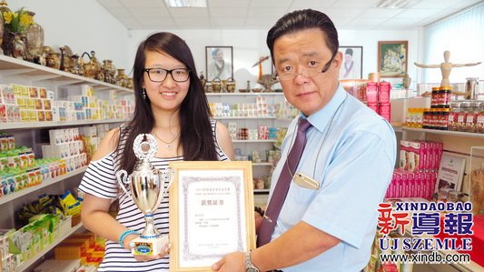 匈牙利東方國藥集團董事長陳震博士（右）為楊可欣（左）頒發(fā)榮譽證書。（匈牙利《新導(dǎo)報》）