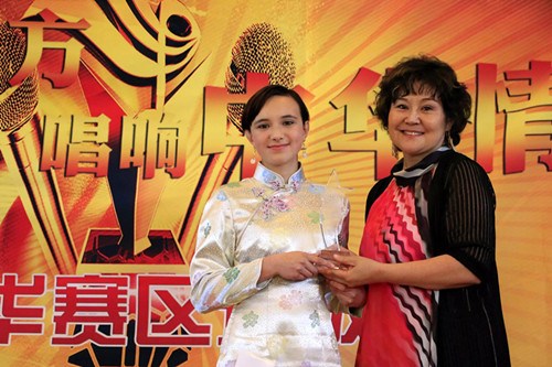加拿大溫哥華賽區(qū)評委王穎老師為Akela頒發(fā)精美冠軍獎杯。(丁玎