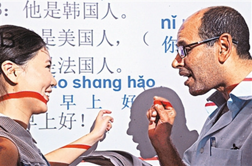 埃及客商埃勒賽義德(右)向老師學說“早上好”。(新華社記者
