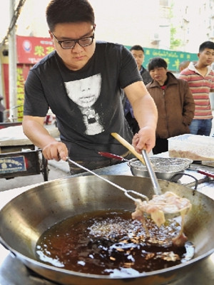 郭方正在炸雞,動(dòng)作相當(dāng)嫻熟老練,一點(diǎn)不像新手。