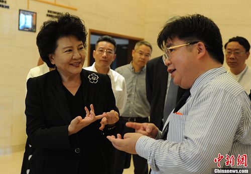 中國國務(wù)院僑辦主任裘援平與微總部科技發(fā)展有限公司董事長徐德清交流。中新社記者