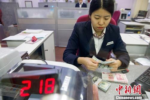 中國(guó)僑網(wǎng)資料圖 銀行工作人員清點(diǎn)貨幣。中新社記者 張?jiān)?攝