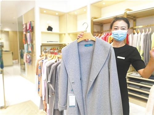 中國僑網(wǎng)圖為鄂爾多斯集團(tuán)銷售員展示出口產(chǎn)品。 本報記者 佘 穎 攝