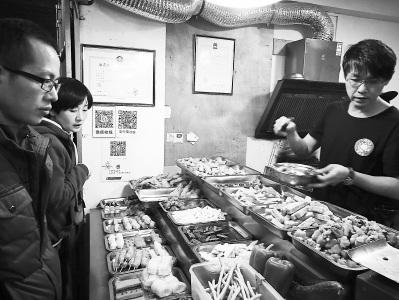 中國(guó)僑網(wǎng)柯武義(右)在店里忙著給顧客打包。