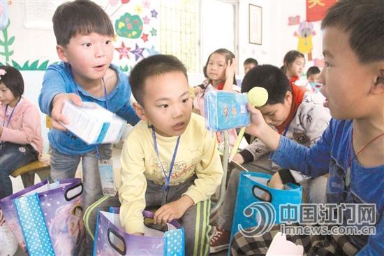 中國僑網(wǎng)留守兒童們收到了禮物顯得十分開心。