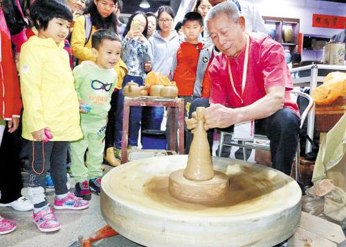 中國僑網(wǎng)資料圖:黃樹藩現(xiàn)場(chǎng)展示手拉朱泥壺陶藝 (來源:羊城晚報(bào))
