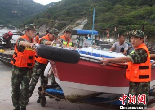 中國僑網(wǎng)圖為邊防官兵幫民眾轉(zhuǎn)移船只。王華 攝