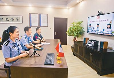 中國僑網(wǎng)民警在溫州市甌海區(qū)“在線警僑工作室”,與法國聯(lián)絡點聯(lián)絡員進行視頻通話。(來源:溫州網(wǎng))