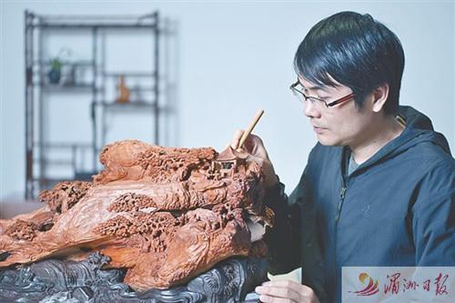 中國僑網(wǎng)圖為林建軍正在進行木雕創(chuàng)作。