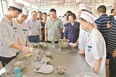 中國僑網(wǎng)專家在指導(dǎo)學(xué)員做粵菜。