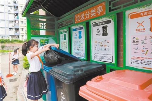 中國(guó)僑網(wǎng)農(nóng)林雙朗小學(xué)學(xué)生將垃圾投放到垃圾分類收集點(diǎn)。