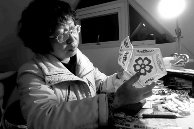 中國僑網(wǎng)非遺傳承人蔡聰慧正在精心制作針刺無骨花燈。(潘珊菊 攝)