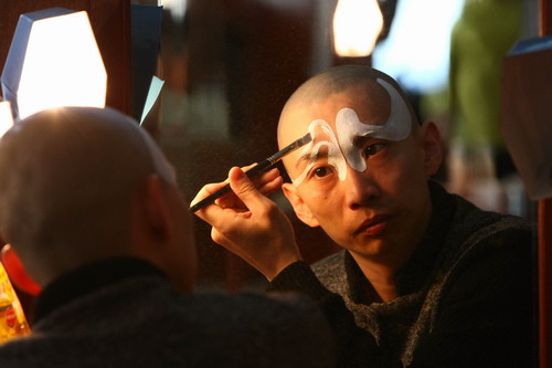 中國(guó)僑網(wǎng)飾演《赤桑鎮(zhèn)》包拯的青年演員方旭在后臺(tái)勾臉 (《今日中國(guó)》/喻捷 圖)
