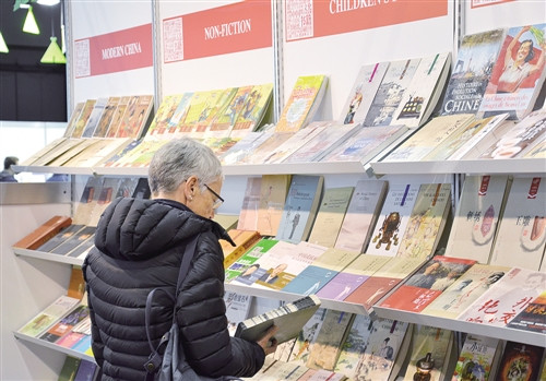 在日內(nèi)瓦書展上,一位瑞士讀者被中國展臺的圖書所吸引(陳建