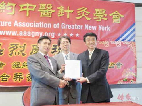 樂貴祥(左)與陳大志(右)簽署合并協(xié)議。(美國(guó)《僑報(bào)》/王伊琳