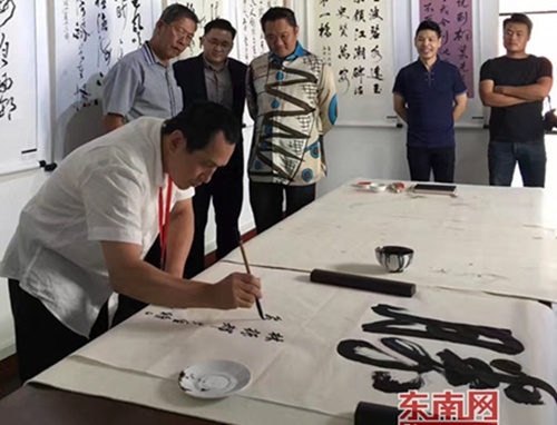在泉州文化周活動上,泉州市書法家協(xié)會主席蔡宗偉正在參與書法交流活動。